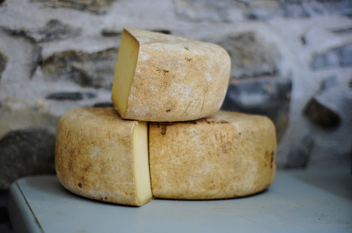 Aged cheese wheels on a stone shelf
